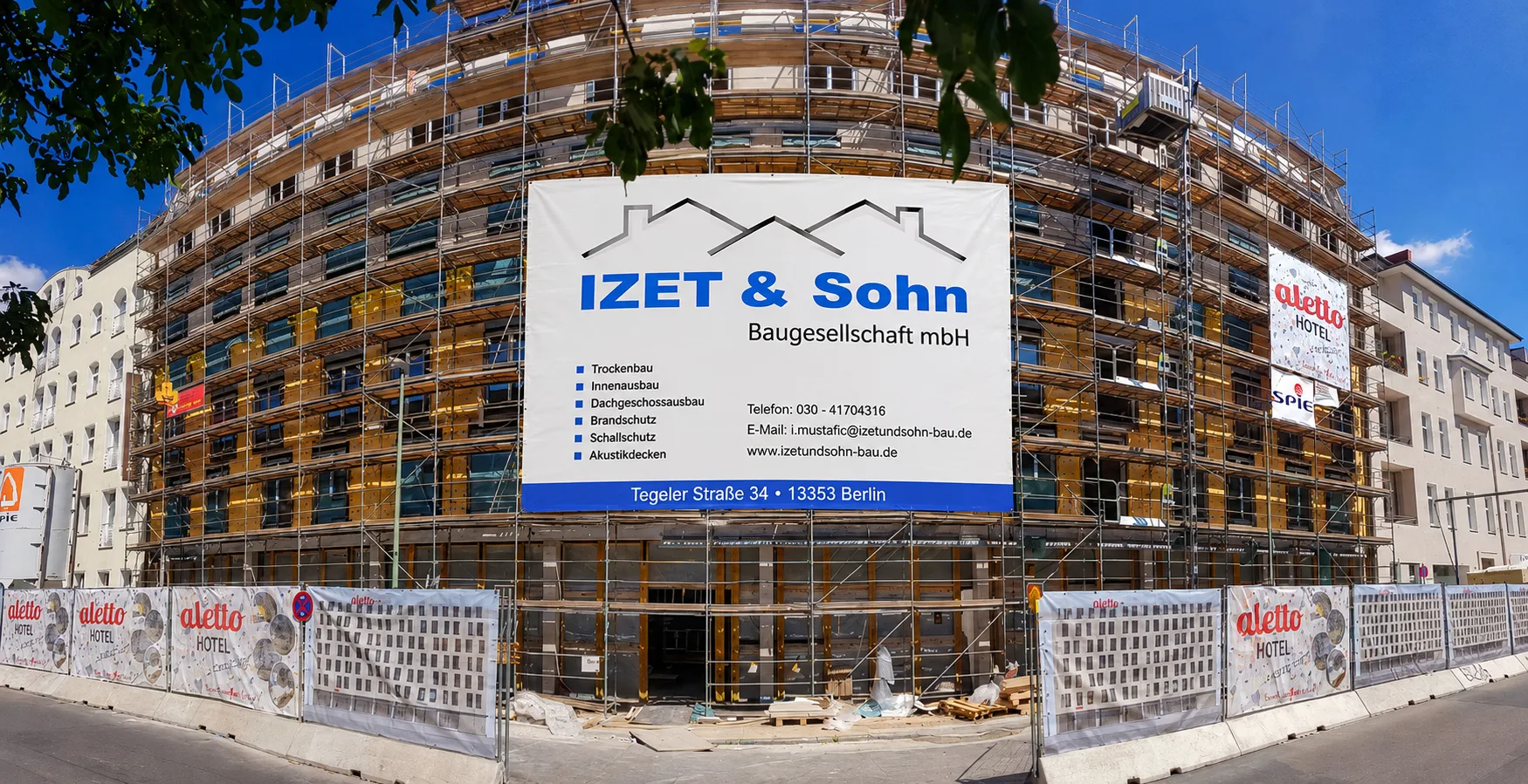 Baustelle der IZET & Sohn Baugesellschaft in Berlin mit Bautafel des Unternehmens